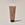 A tube of ACURE Brightening Body Scrub against a neutral background.